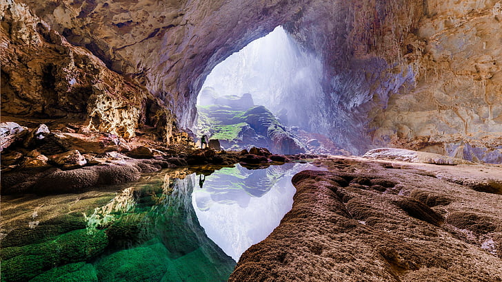 landscape photography of brown cave with body of water in the middle