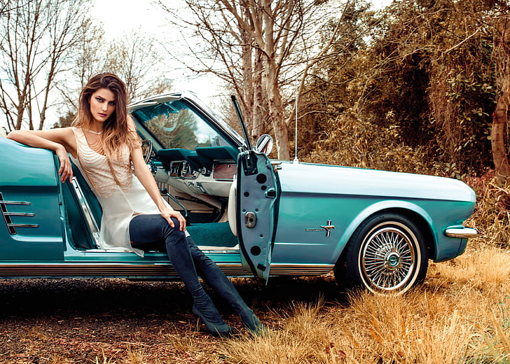 classic blue coupe, woman in white sleeveless top and blue jeans
