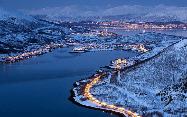 City lights of Tromso, Norway, winter night, mountain with snow cap