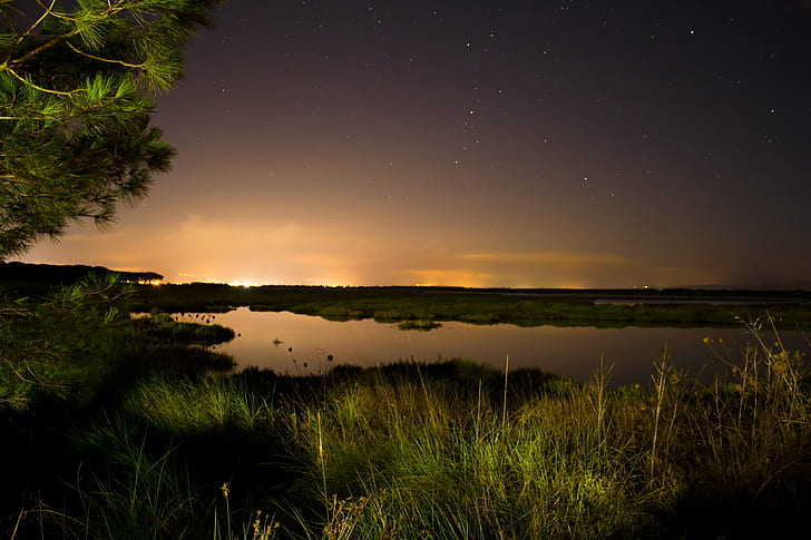 body of water between green grass field during night time, City lights, HD wallpaper