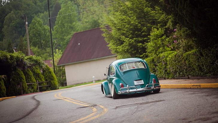 green Volkswagen Beetle on gray asphalt road during daytime, car