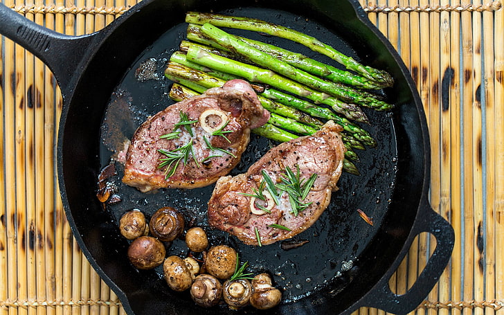 two slice of cooked meat and asparagus, steak, mushrooms, pan