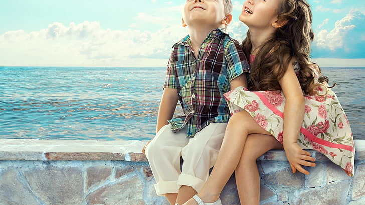 boy and girl sitting on brown concrete seaside seat during daytime, HD wallpaper
