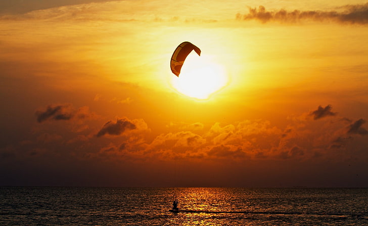 Kitesurfing At Sunset, silhouette of parachute during golden hour