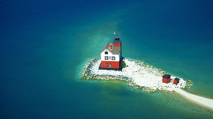 red and white house near body of water during daytime, lighthouse