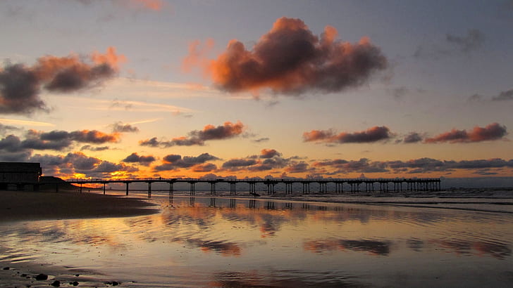 Coast landscape, bridge, sand, sea, sunset, red sky, silhouette of pier on body of water