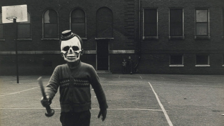 man wearing skull mask, hat, monochrome, sweater, scary face