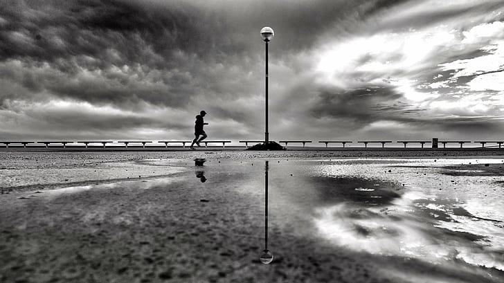 gray scale photo of person jogging near to body of water, morning
