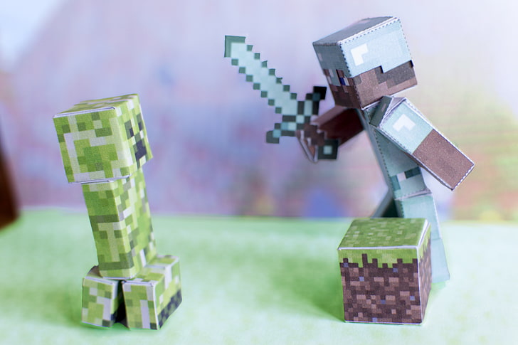 Minecraft Creeper and character with diamond sword cardboard figures, shallow focus photography of green and blue Minecraft figure