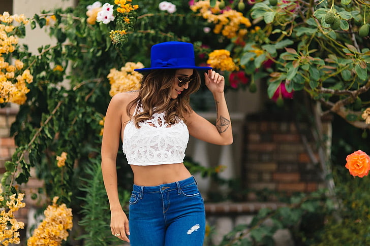 woman in white crop top and blue denim bottoms standing near flowers, HD wallpaper