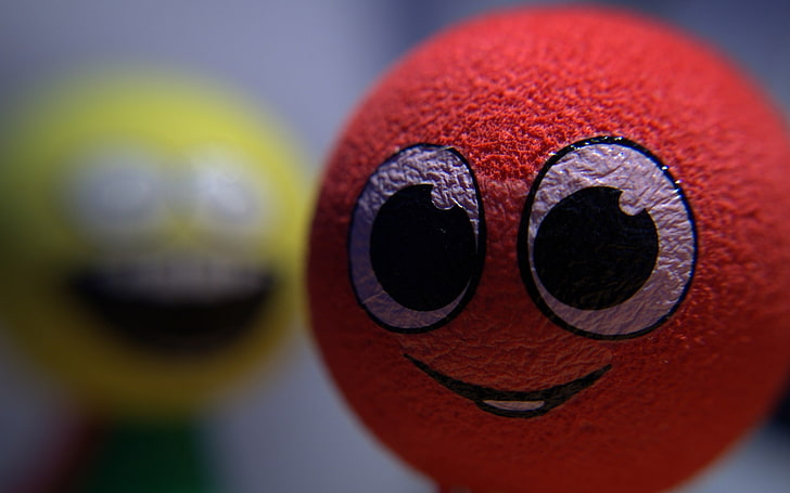 red emoji ball, smiley, blurred, close-up, no people, multi colored