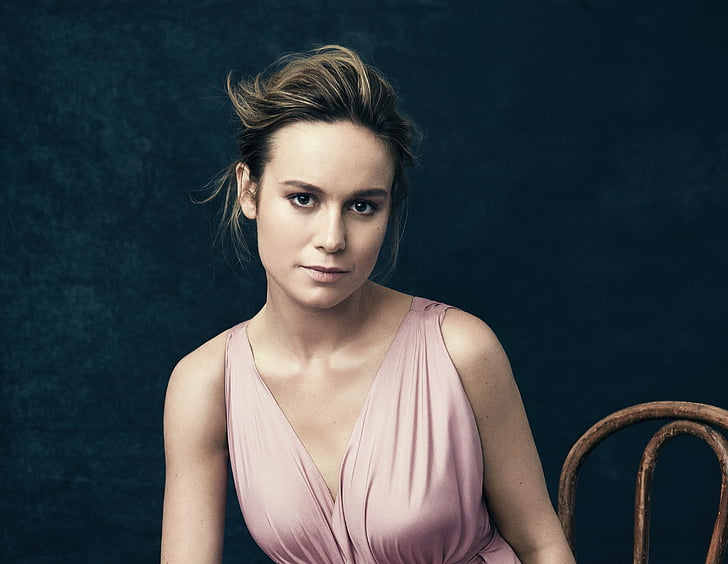 woman in gray sleeveless top sitting on wooden chair, Brie Larson