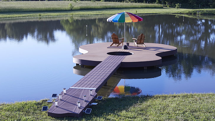 guitar-shaped brown and beige dock with two aderondak and patio umbrella