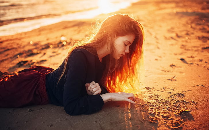Long hair girl lying on beach, sunshine, dusk