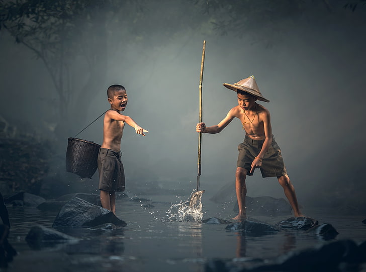 Boy Catching Fish with a Spear, boy's black shorts, Asia, Thailand