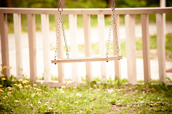beige wooden swing chair, greens, grass, flowers, background