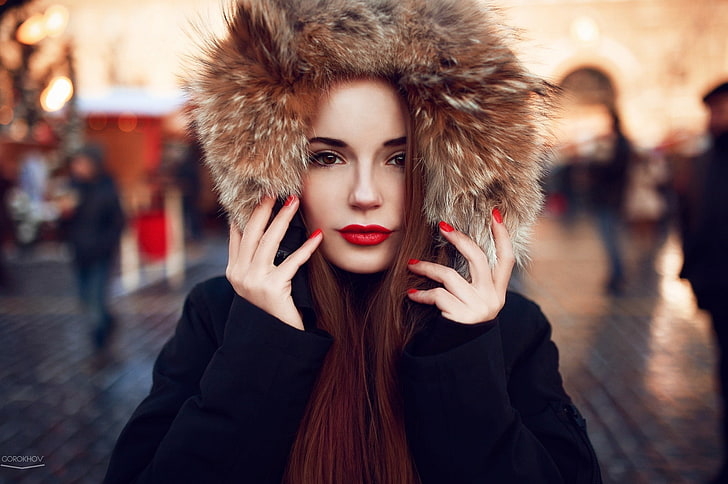 women's black and brown parka coat, selective focus photography of woman wearing fur hoodie