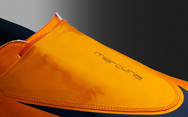 unpaired orange and black Nike Mercurial, text, yellow, indoors