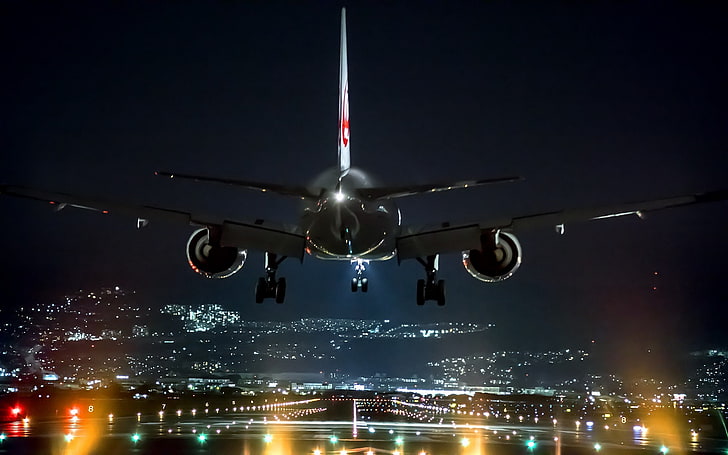 black and white airplane, passenger plane getting ready on runway to land at night time
