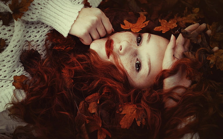 women's pink hair, woman with red haired lying on brown leaves