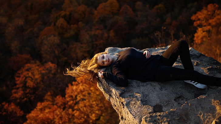 women's black long-sleeved shirt, woman in black shirt laying on rocky mountain