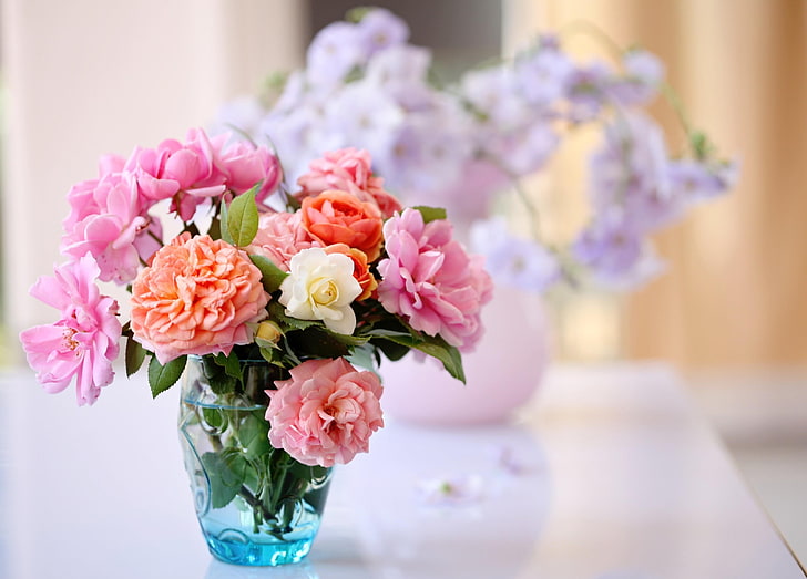 variety of flowers and blue glass vase centerpiece, roses, garden