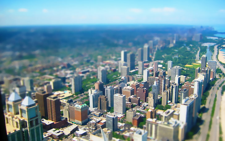 tilt shift photography of cityscape, aerial photography of city buildings and green trees under blue sky and white clouds during daytime