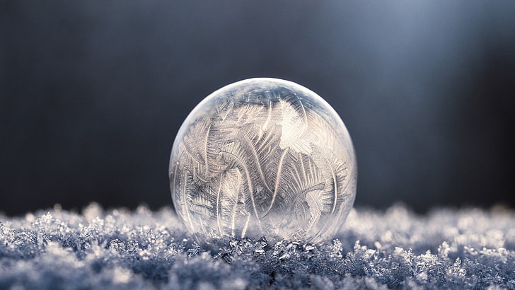 clear glass ball, round clear crystal on ground photograph, bubbles