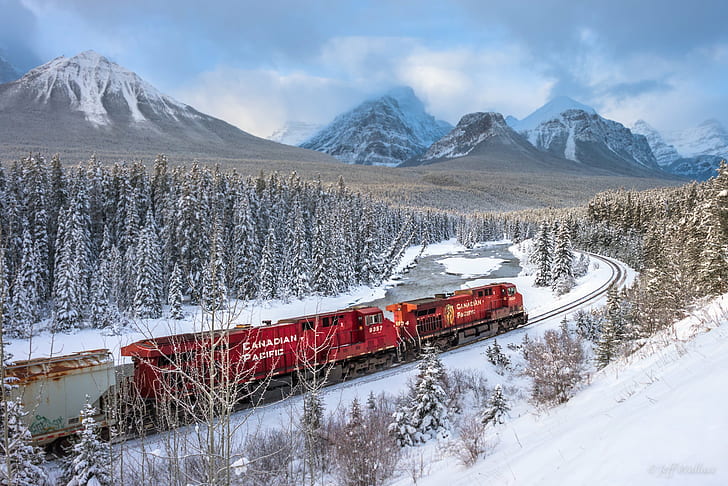 photo of red train surrounded by trees during snow season, banff national park, banff national park