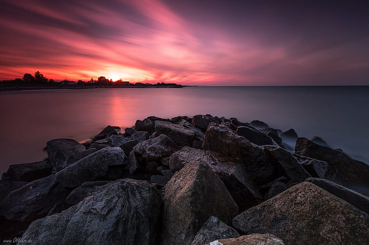 landscape photography of rocks near body of water during golden hour