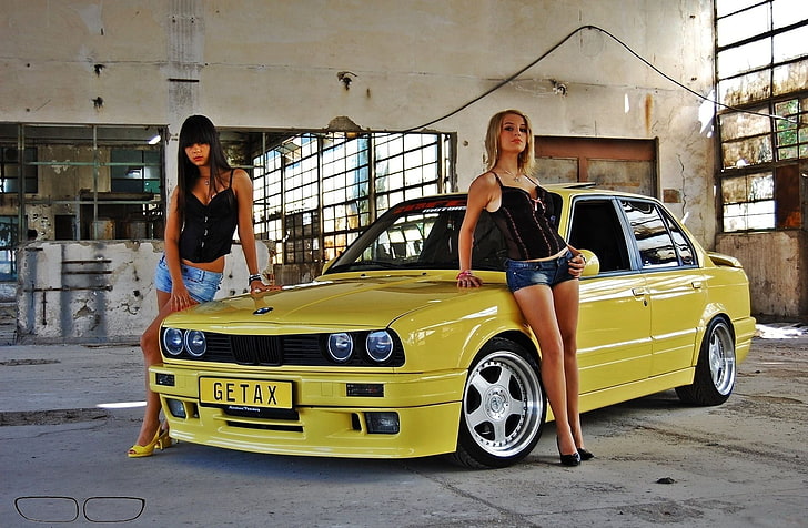 yellow BMW sedan, Girls, Two beautiful girls, look at the camera