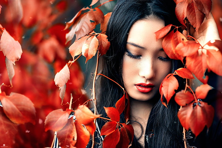 women's red lipstic k, woman under red leaf plant closeup photography