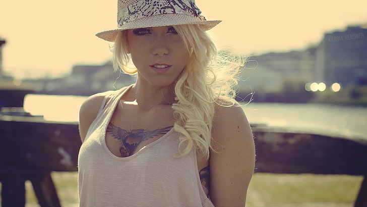 women's white tank top, tattoo, hat, millinery, blonde, looking at viewer