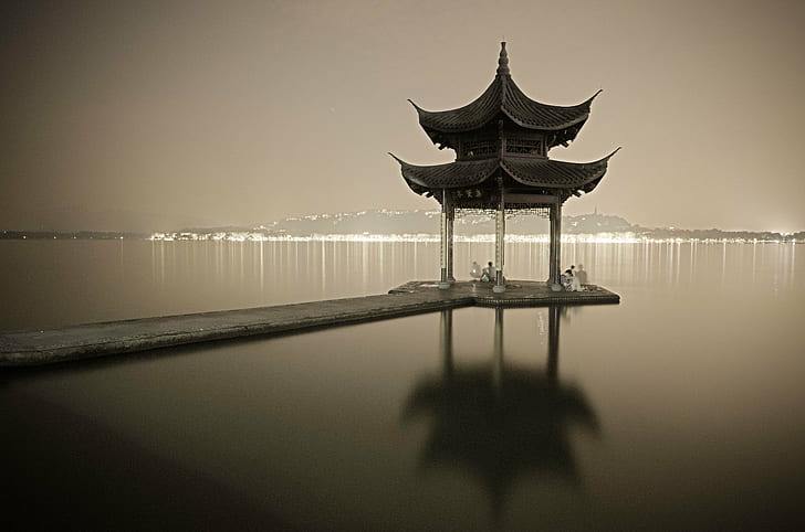 grayscale photography of pagoda gazebo near body of water, lake