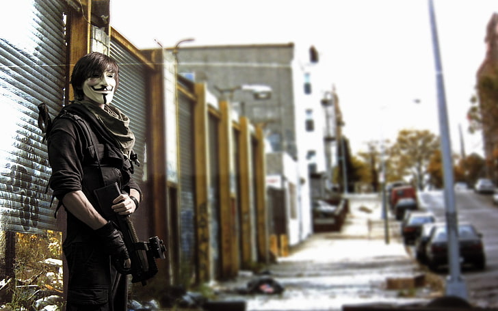 man standing near roll-up door, FN P90, gun, mask, urban, street