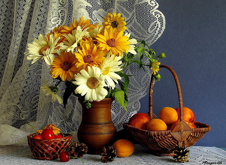 yellow and white daisy flower centerpiece beside fruits in baskets
