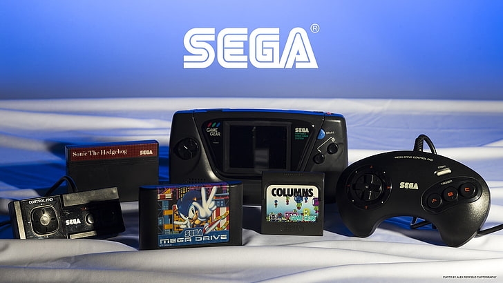 black Sega console with controller and game cartridges, retro games