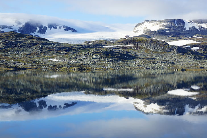 green grasses beside body of water surrounded with snow ground mountain during daytime, norway, norway