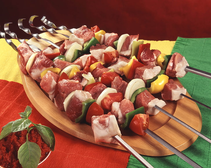 several raw barbecue meat sticks, kebabs, small board, skewers