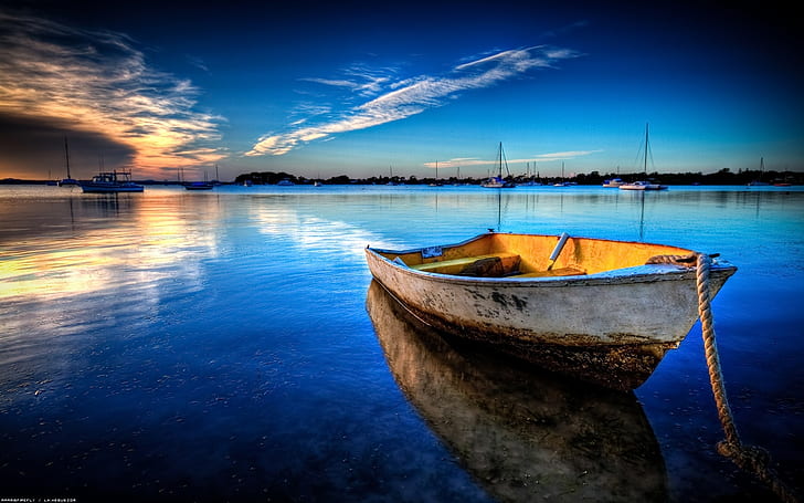 Exceptional Boat Anchored, white and brown wooden boat, sunset