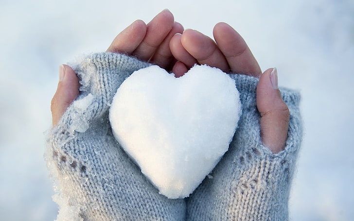 white heart-shaped snow, human hand, cold temperature, winter