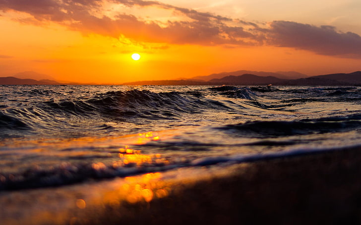 photo of seashore during golden hour, waves, sunset, depth of field