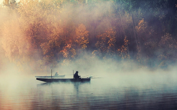 silhouette of person on boat, photo of man sailing on boat between forest trees
