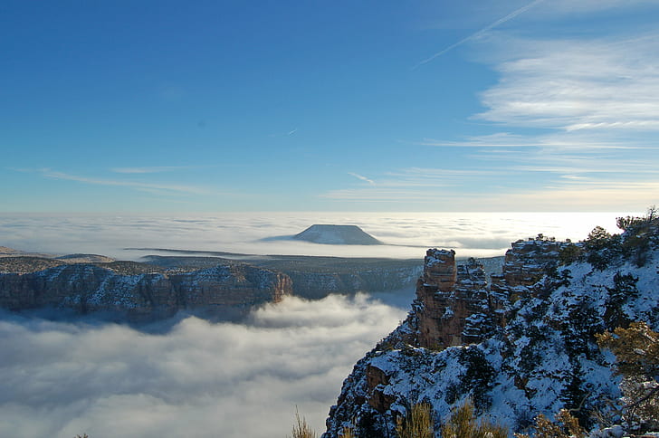 brown snow covered mountain surrounded by sea of clouds during daytime, grand canyon national park, grand canyon national park