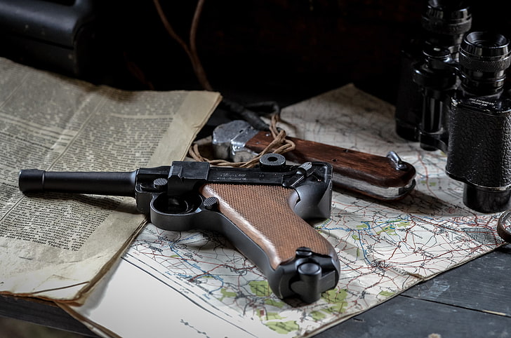 black and brown lugger pistol, gun, map, newspaper, binoculars