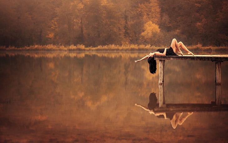 women's black sleeveless dress, woman lying on gray wooden dock near lake during golden hour, HD wallpaper