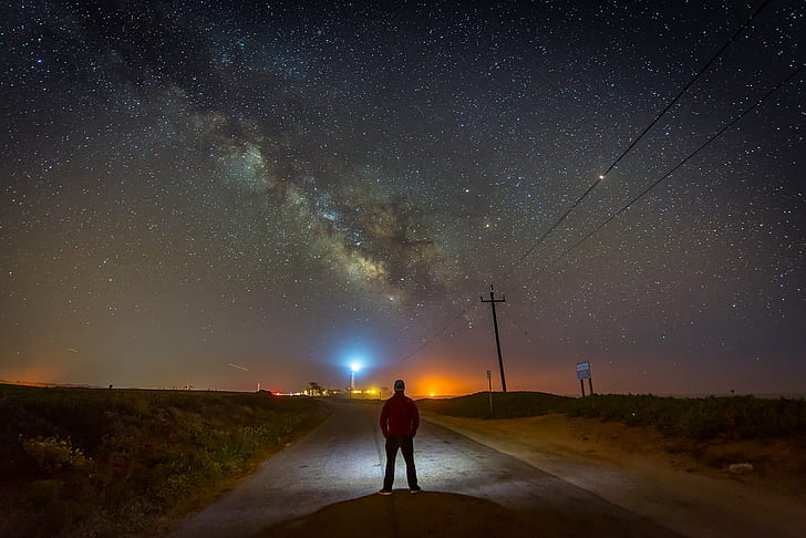 man wearing black pants while having a photography on black milky way galaxy