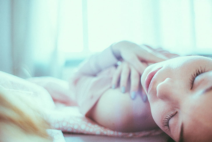 women, lying on back, closed eyes, face, hands on chest, blue nails