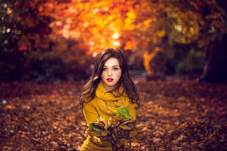 women's brown top, woman wearing yellow sweatshirt in forest surrounded by dried leaves