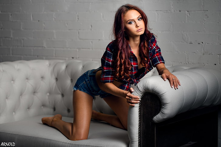 women, tanned, jean shorts, plaid shirt, couch, kneeling, wall